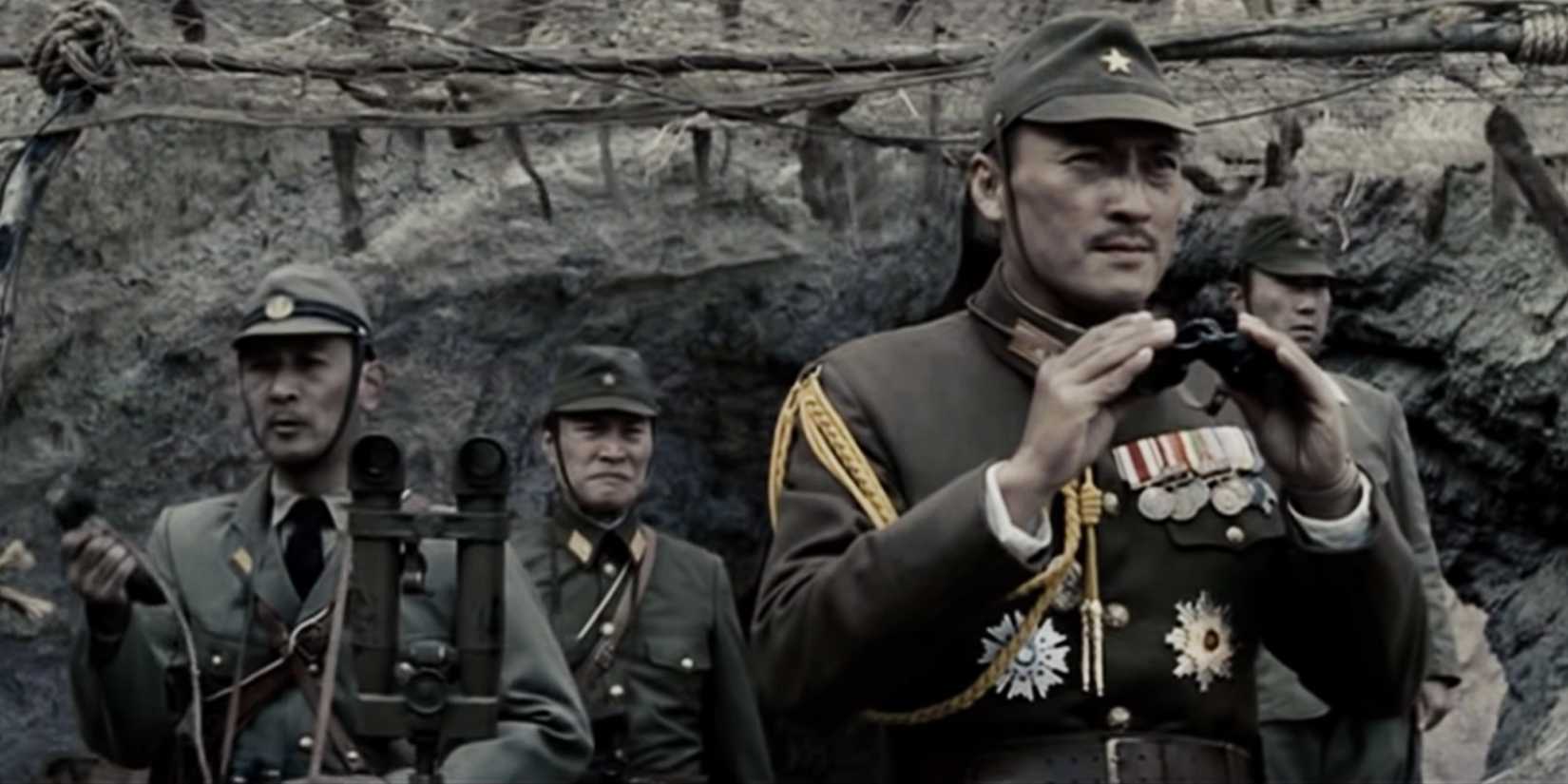 Ken Watanabe in a military uniform stands with others outside a dirt bunker in Letters From Iwo Jima.