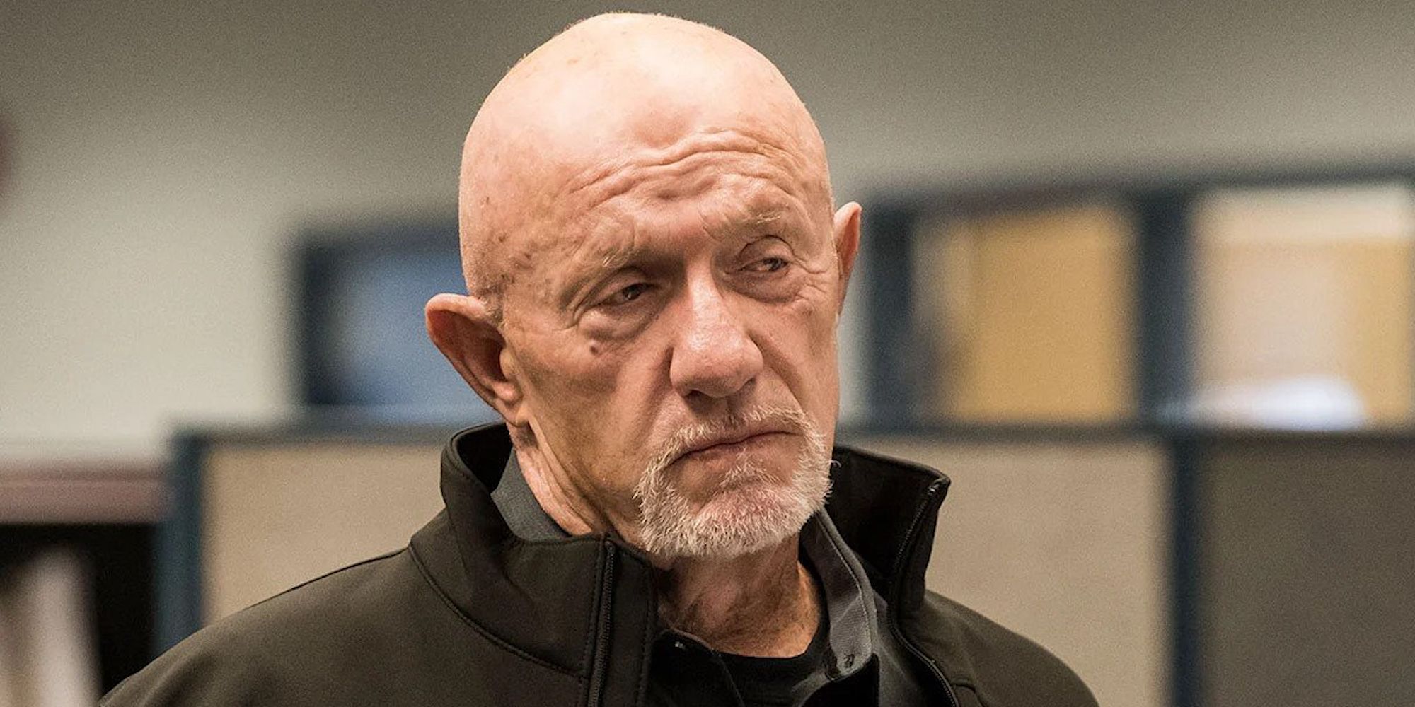 Mike standing alone in an office, looking unimpressed in Breaking Bad.
