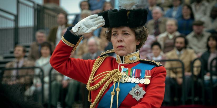 Queen Elizabeth saluting while riding a horse in a parade in 'The Crown'