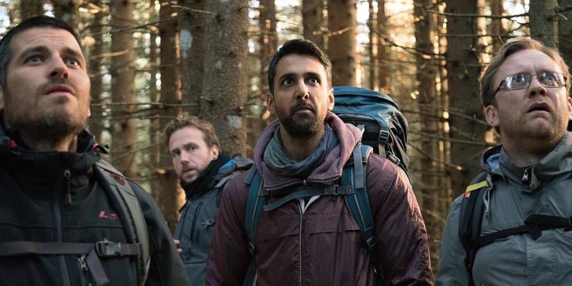 Sam Troughton, Rafe Spall, Arsher Ali, Robert James-Collier standing together in the woods in The Ritual