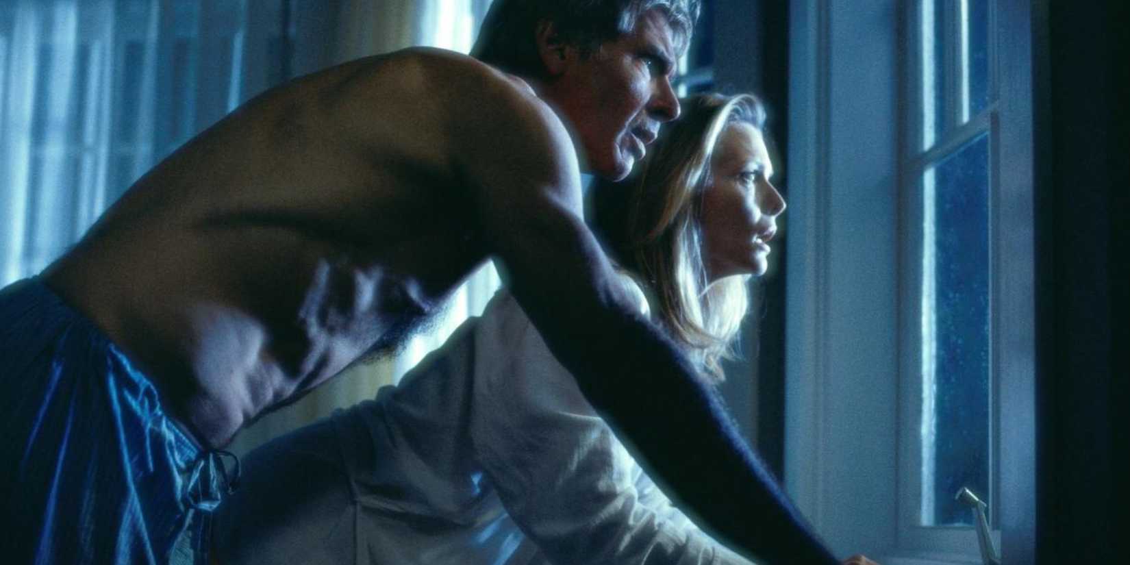 Harrison Ford and Michelle Pfeiffer as Norman and Claire Spencer, looking out the window at night in What Lies Beneath