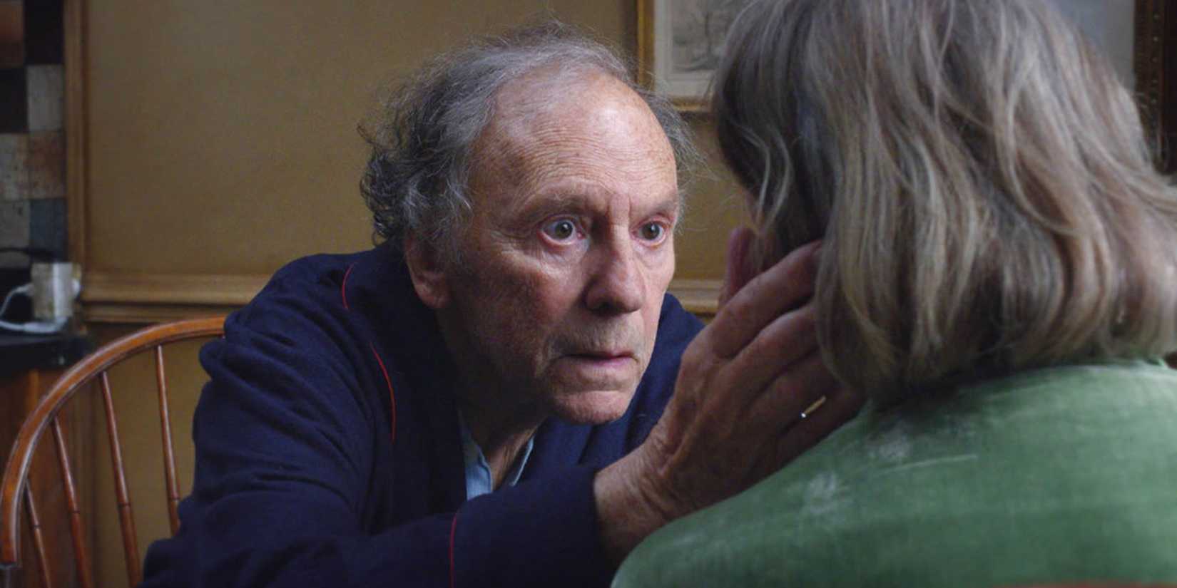 Jean-Louis Trintigant as Georges holding a woman's face in Amour
