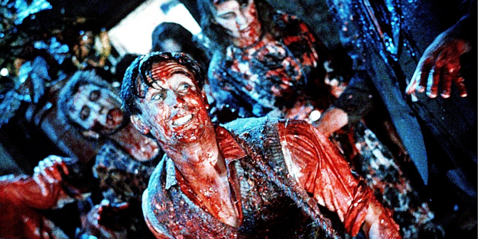 Lionel is covered in blood and surrounded by zombies in Dead Alive