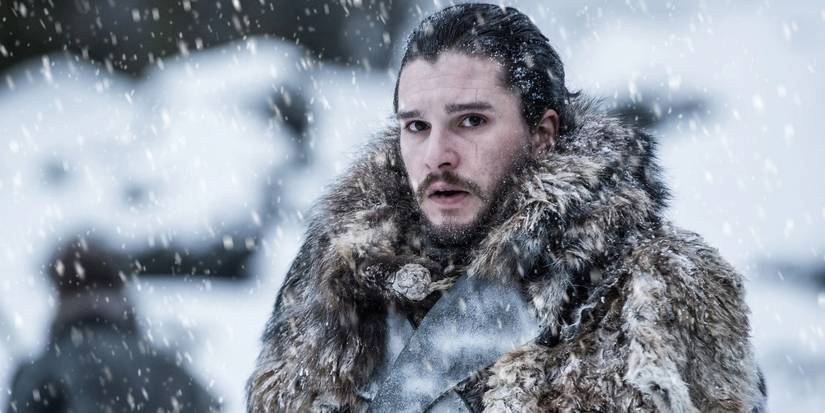 Kit Harington as Jon Snow standing in a fur coat in the snow in 'Game of Thrones'