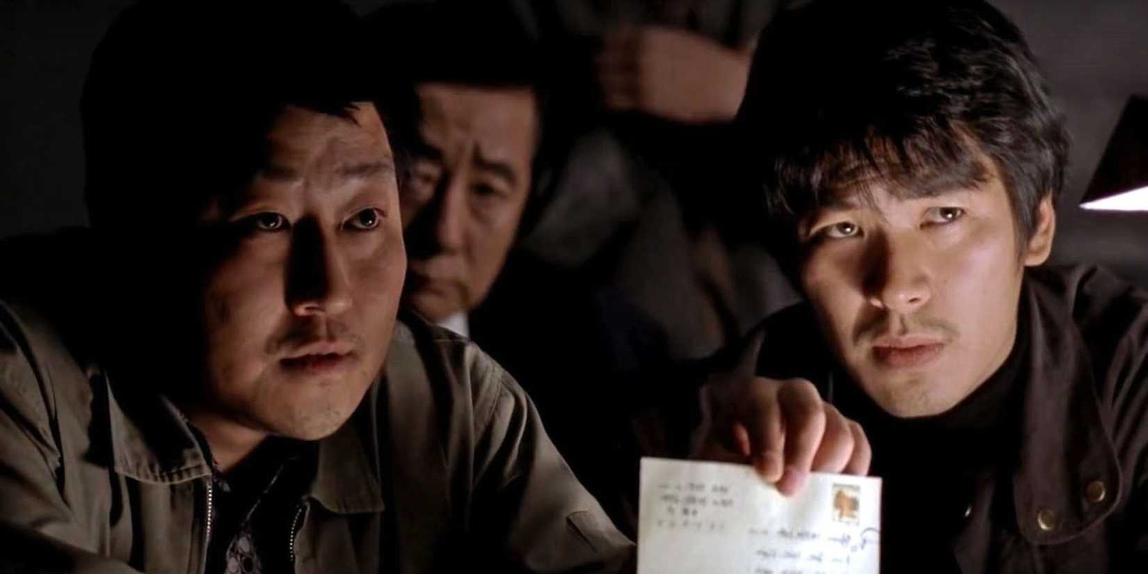 Three detectives are showing a piece of evidence to the suspect