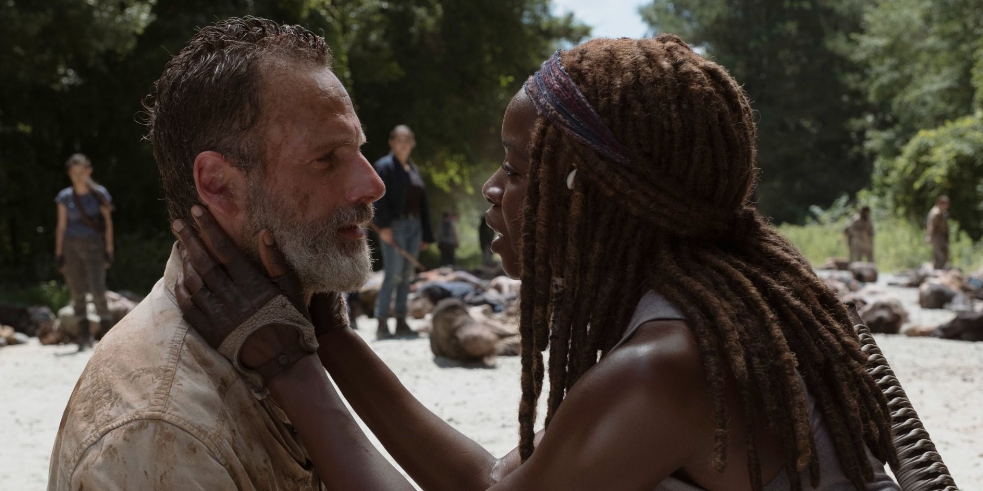 Michonne (Danai Gurira) kneeling with her hand on Rick's (Andrew Lincoln) face in The Walking Dead