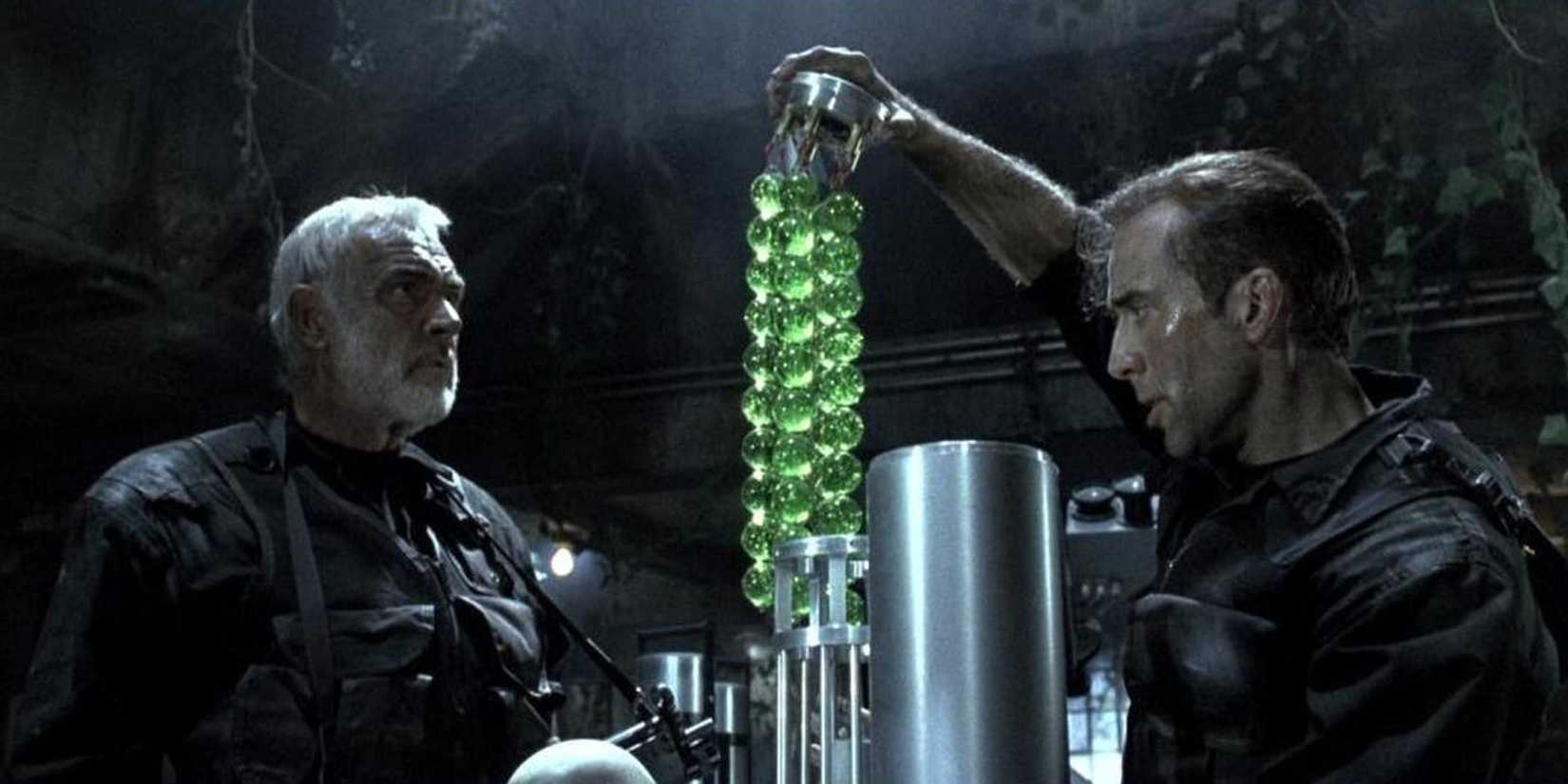 Jon looking at Stanley manipulating tiny green balls filled with toxic gas in The Rock