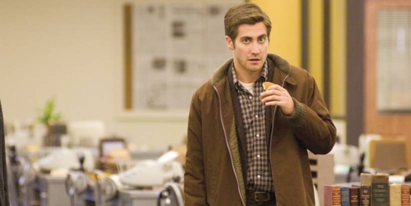 A man is standing with a piece of pancake in his hand