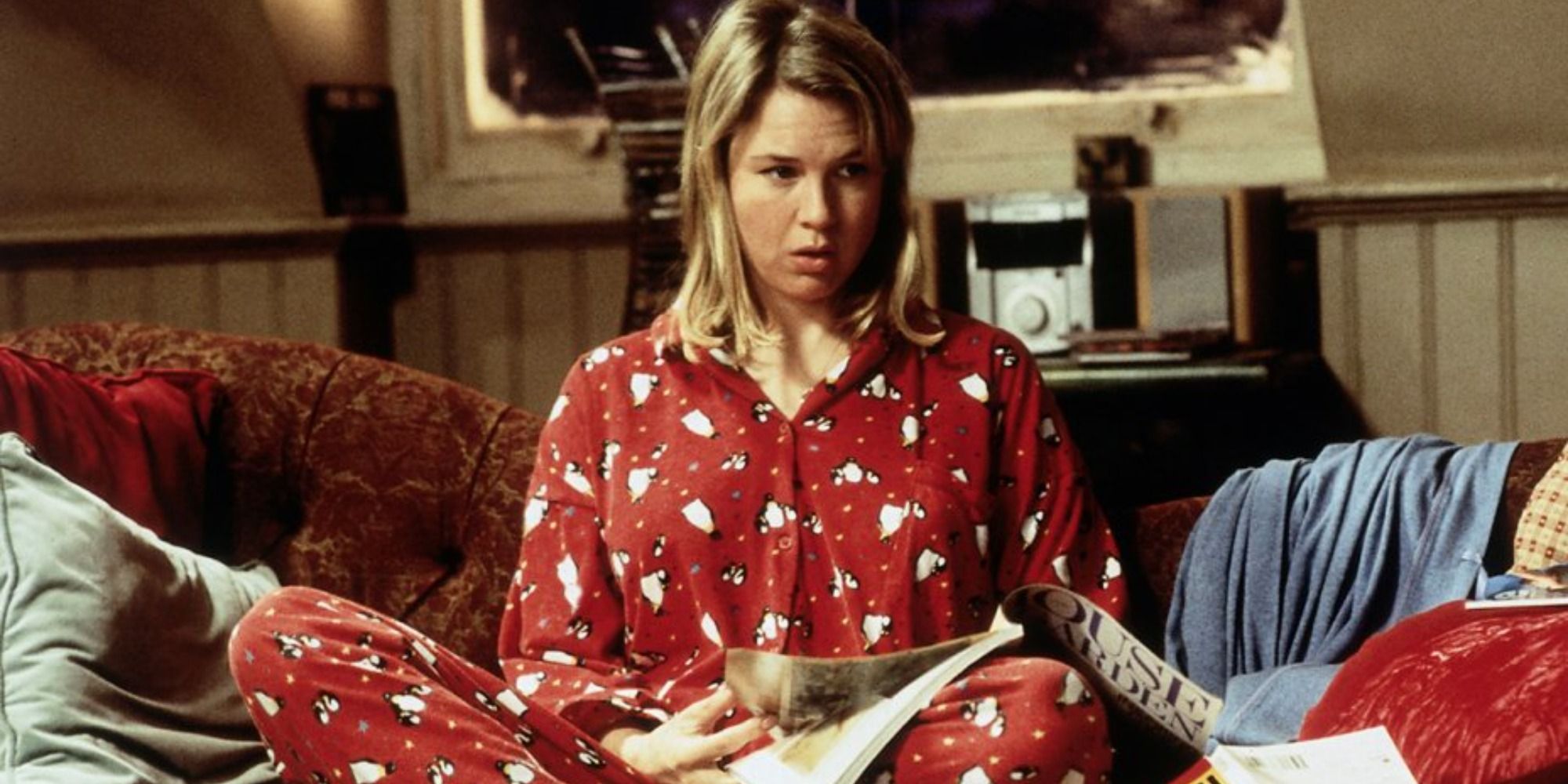 Rene Zellweger in her pyjamas looking confused on the couch 