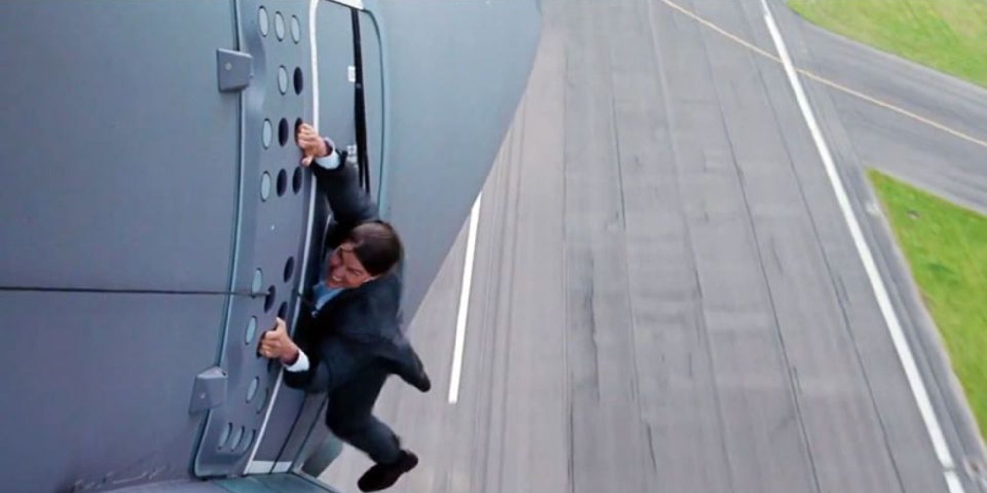 Ethan Hunt hanging on the side of the plane 