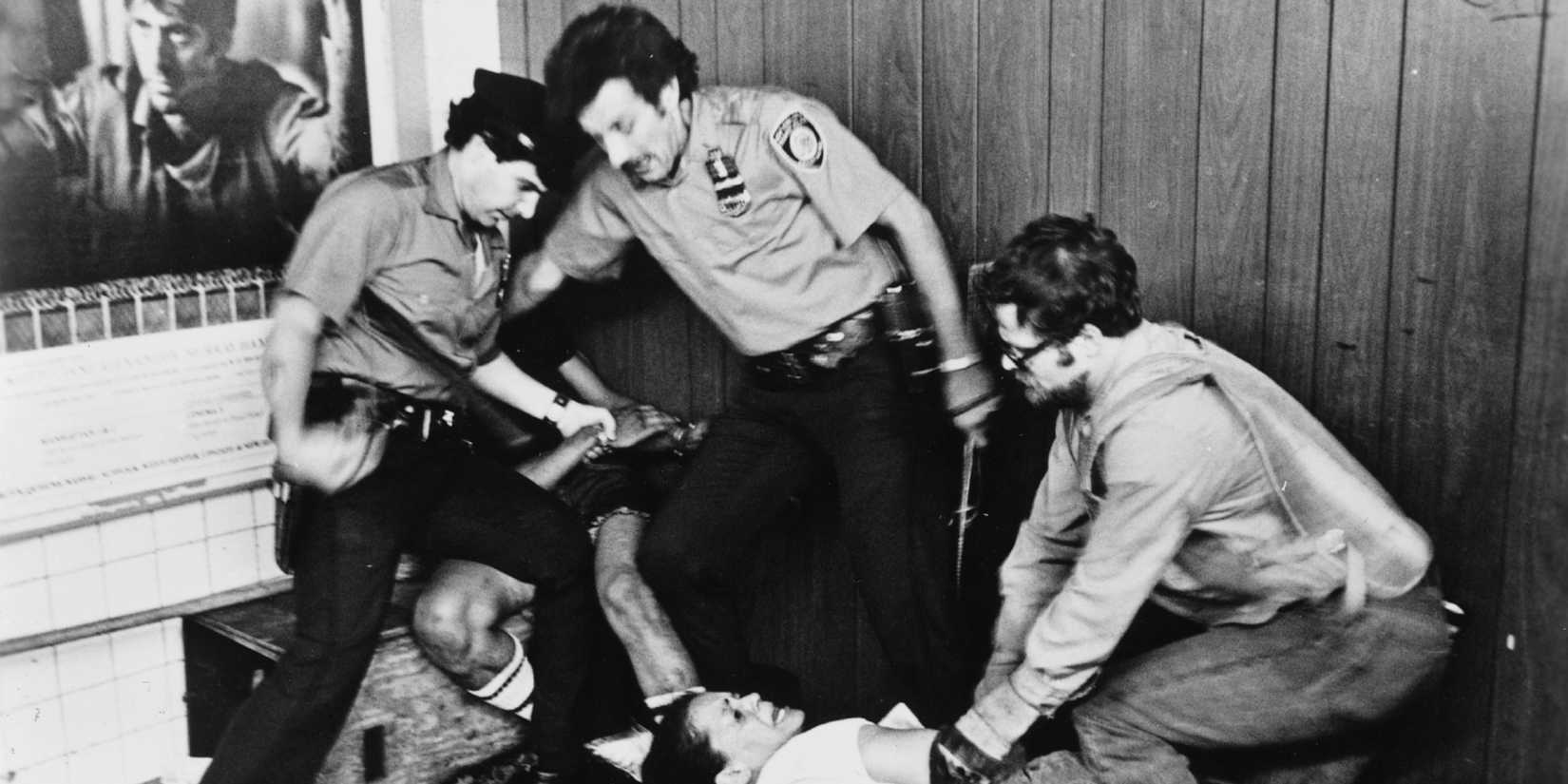 A group of men subduing a man and a woman in The Killing of America