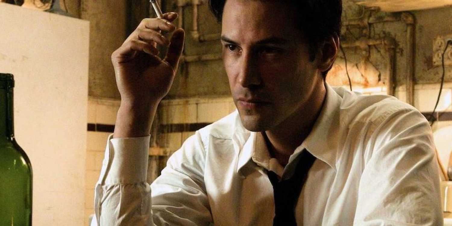 Constantine (Keanu Reeves) sits and smokes while listening to someone off camera