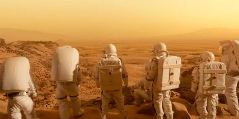 Astronauts stand on a dusty, barren landscape and look out to the distance in For All Mankind.
