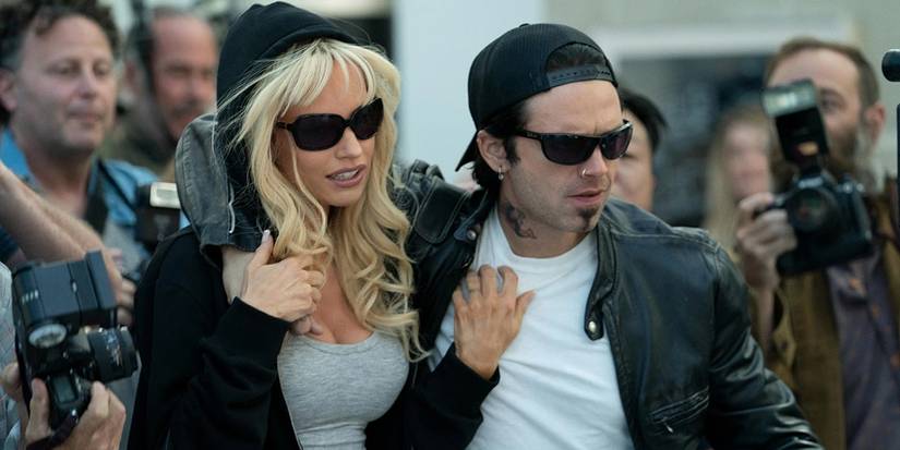 Pamela Anderson (Lily James) and Tommy Lee (Sebastian Stan) wearing sunglasses, trying to walk past paparazzi.