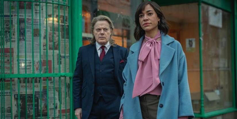 Cush Jumbo next to a grumpy man in a blue suit in Netflix's 'Stay Close'