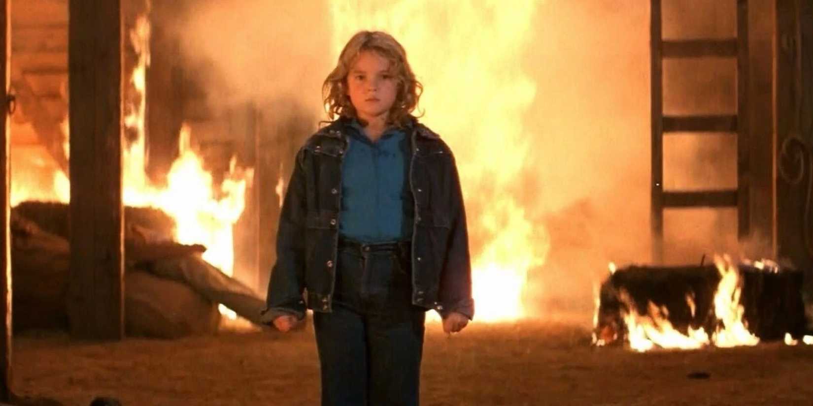 Drew Barrymore as Charlie walks away from fire in Firestarter.