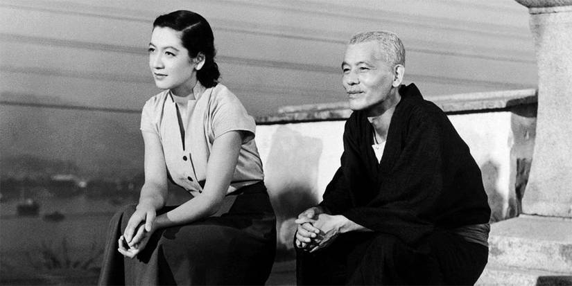 Setsuko Hara and Chishū Ryū sitting on a Japanese rooftop in 'Tokyo Story'