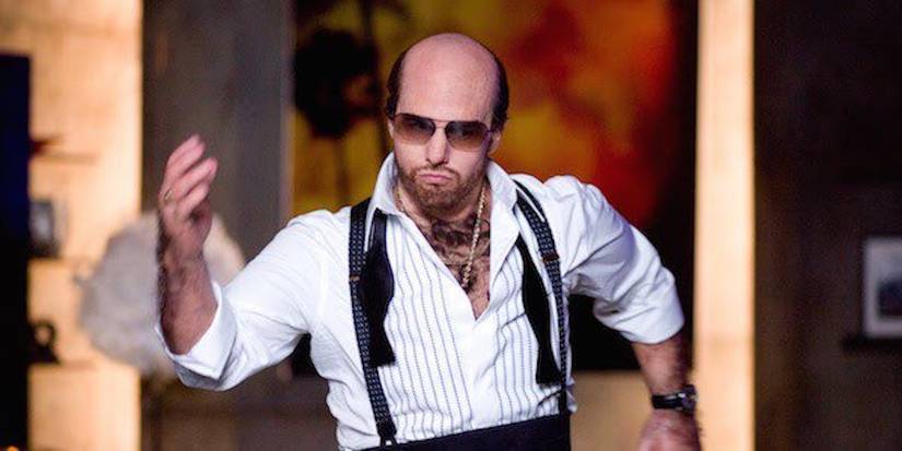 Tom Cruise with a bald head and hairy chest as Les Grossman dancing in Tropic Thunder.