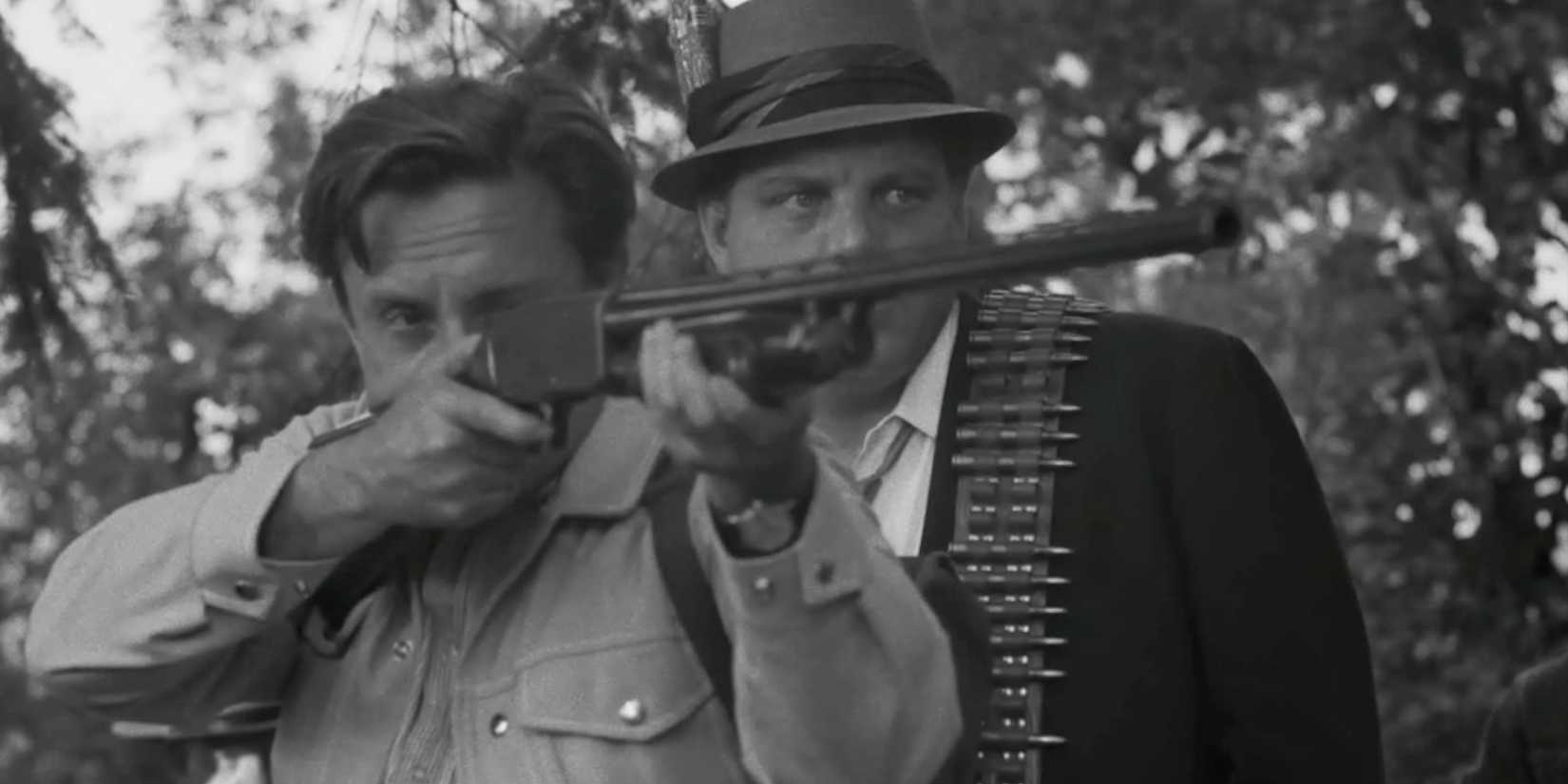 A man pointing a rifle ahead while another man looks on in Night of the Living Dead Headshot