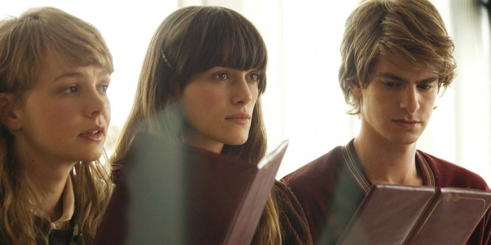 Ruth (Keira Knightley), Kathy (Carey Mulligan), and Tommy (Andrew Garfield) sitting together in 'Never Let Me Go'