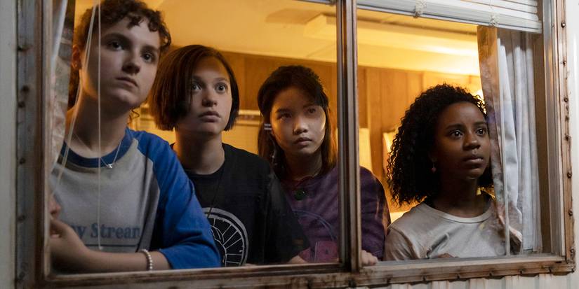  Erin (Riley Lai Nelet), Tiff (Camryn Jones), Mac (Sofia Rosinsky), and KJ (Fina Strazza)look out a window with anxious expressions in Paper Girls