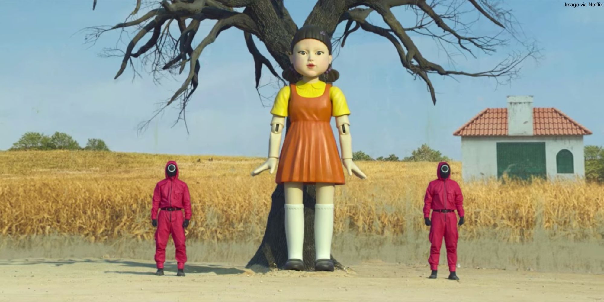 The doll from the first game in Squid Game and staff in pink next to her