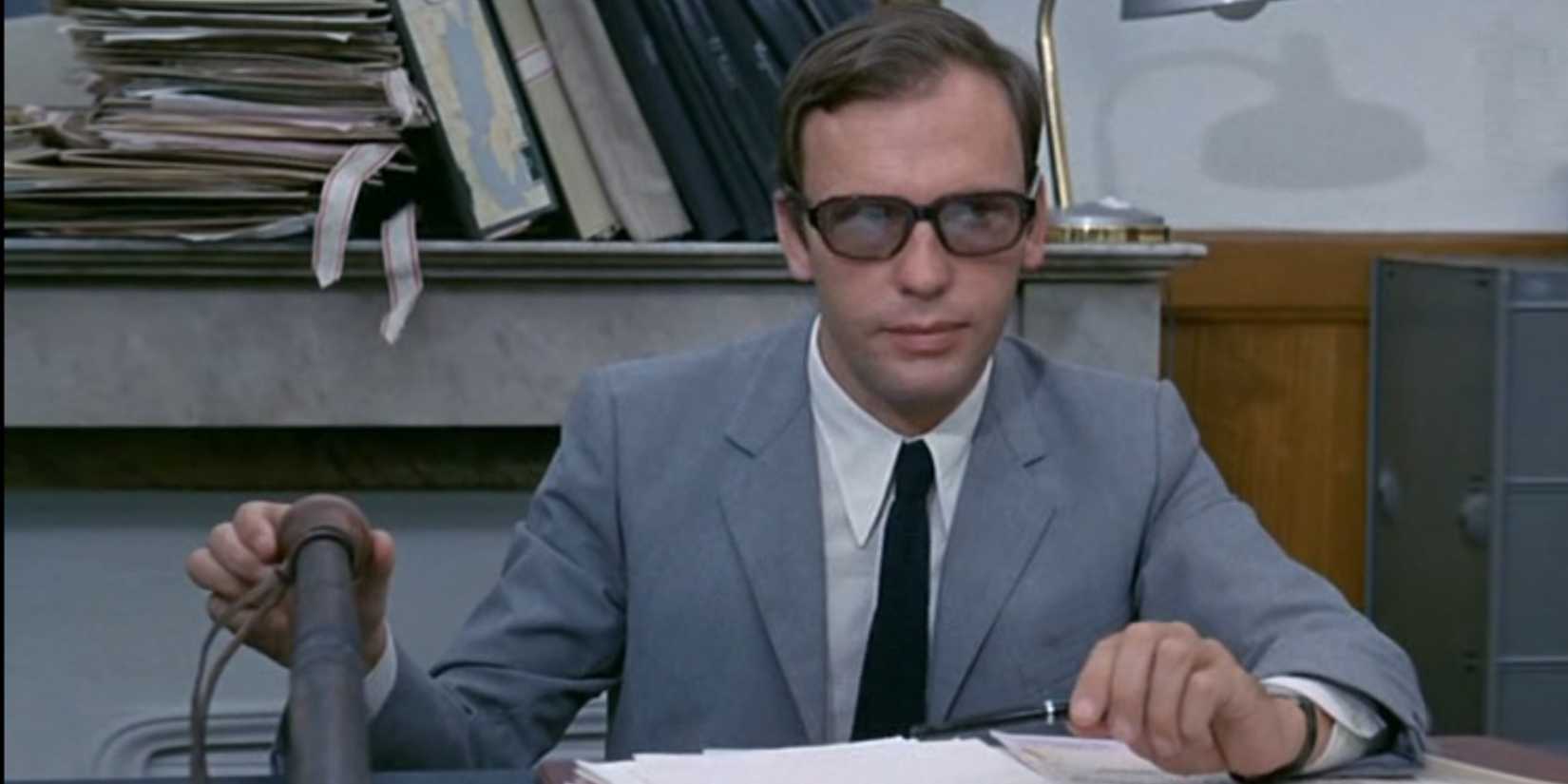 Jean-Louis Trintignant sitting at a desk in Z (1969)