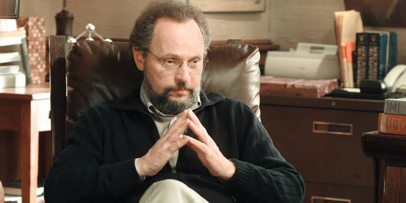 Billy Crystal as Ben Sobel sitting in a chair with glasses on in Analyze This