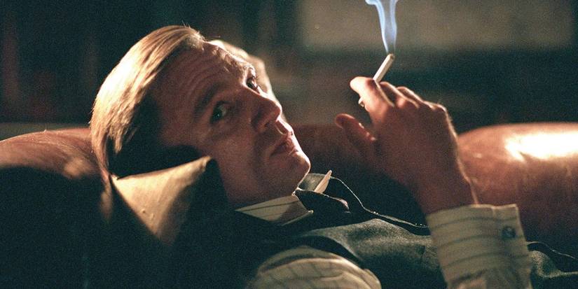 Daniel Craig as Conor Rooney laying down and smoking while looking off-camera in Road to Perdition.