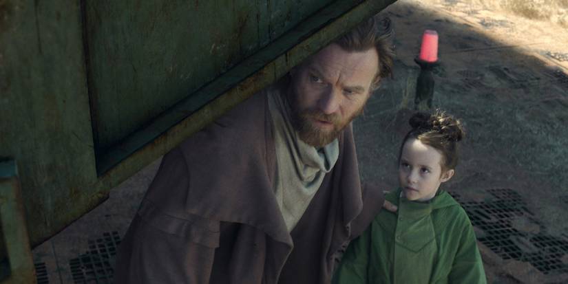 Obi-Wan Kenobi hides with a young Leia behind a metal structure in Obi-Wan Kenobi.