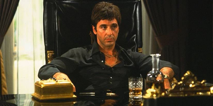 Formidable gangster Tony Montana, played by Al Pacino, sits behind his decadent desk.