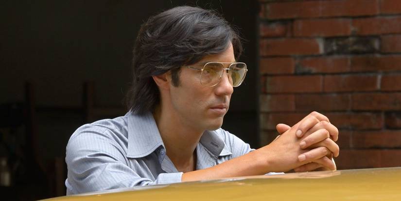 Tahar Rahim as Charles Sobhraj leaning on a car in The Serpent