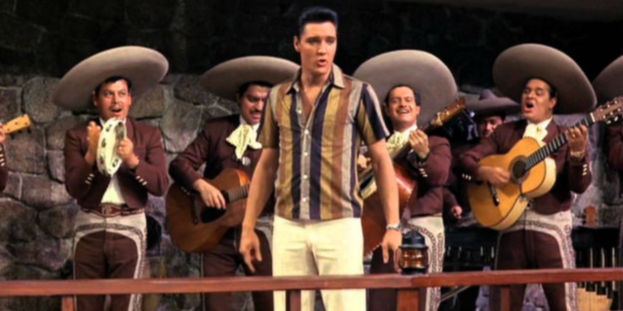 Elvis Presley with a mariachi band behind him singing