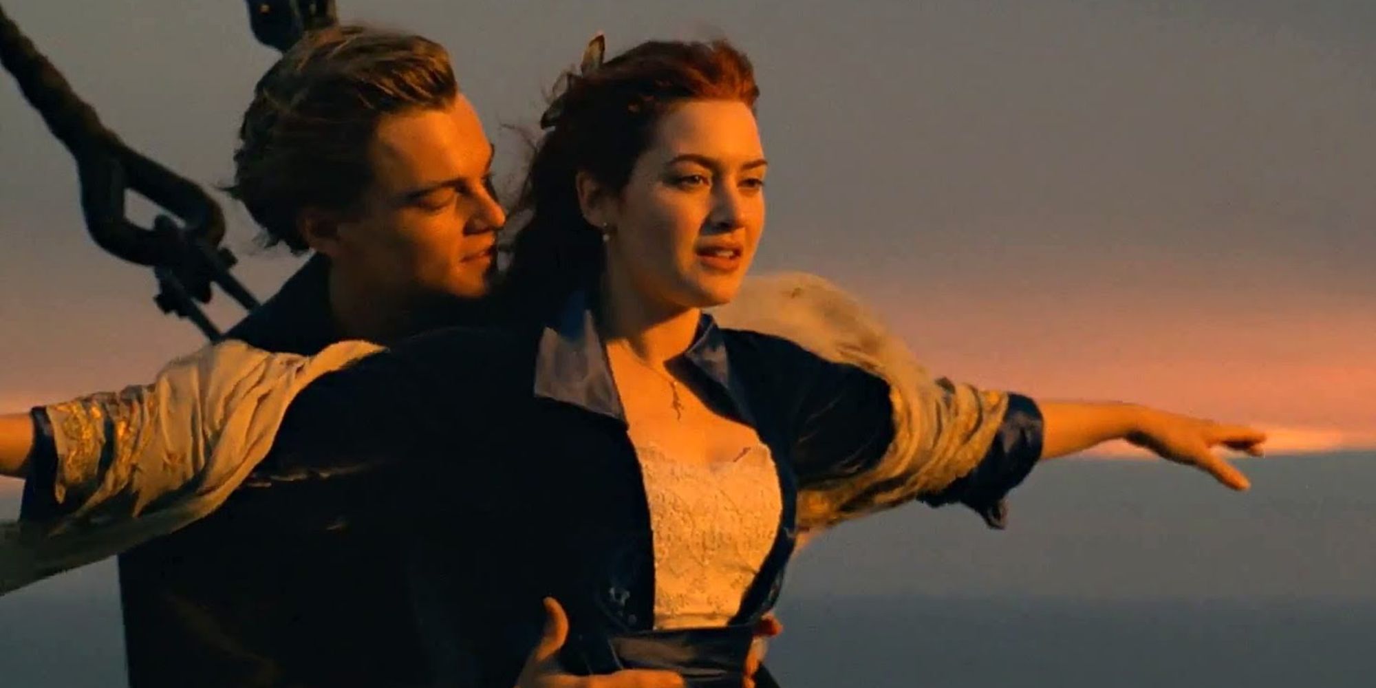 Jack hugging Rose from behind while her arms are outstretched at the front of the boat