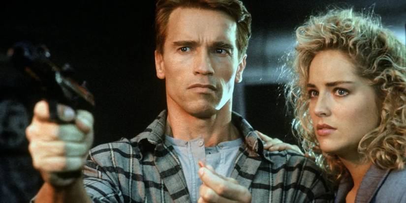 Quaid pointing a gun at someone and Lori standing right beside him 