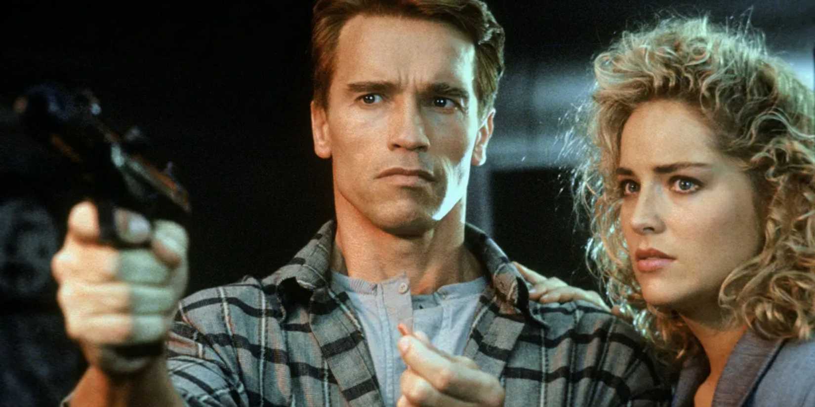 Quaid pointing a gun at someone and Lori standing right beside him 