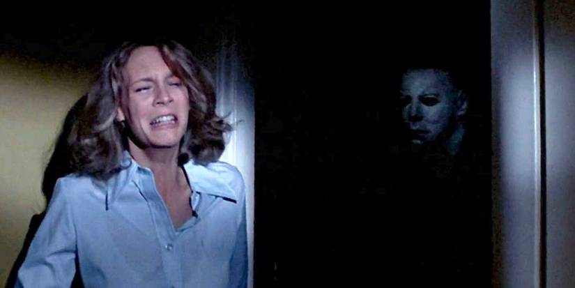 A frightened Laurie Strode (Jamie Lee Curtis) doesn't know Michael Myers is standing behind her in Halloween (1978).