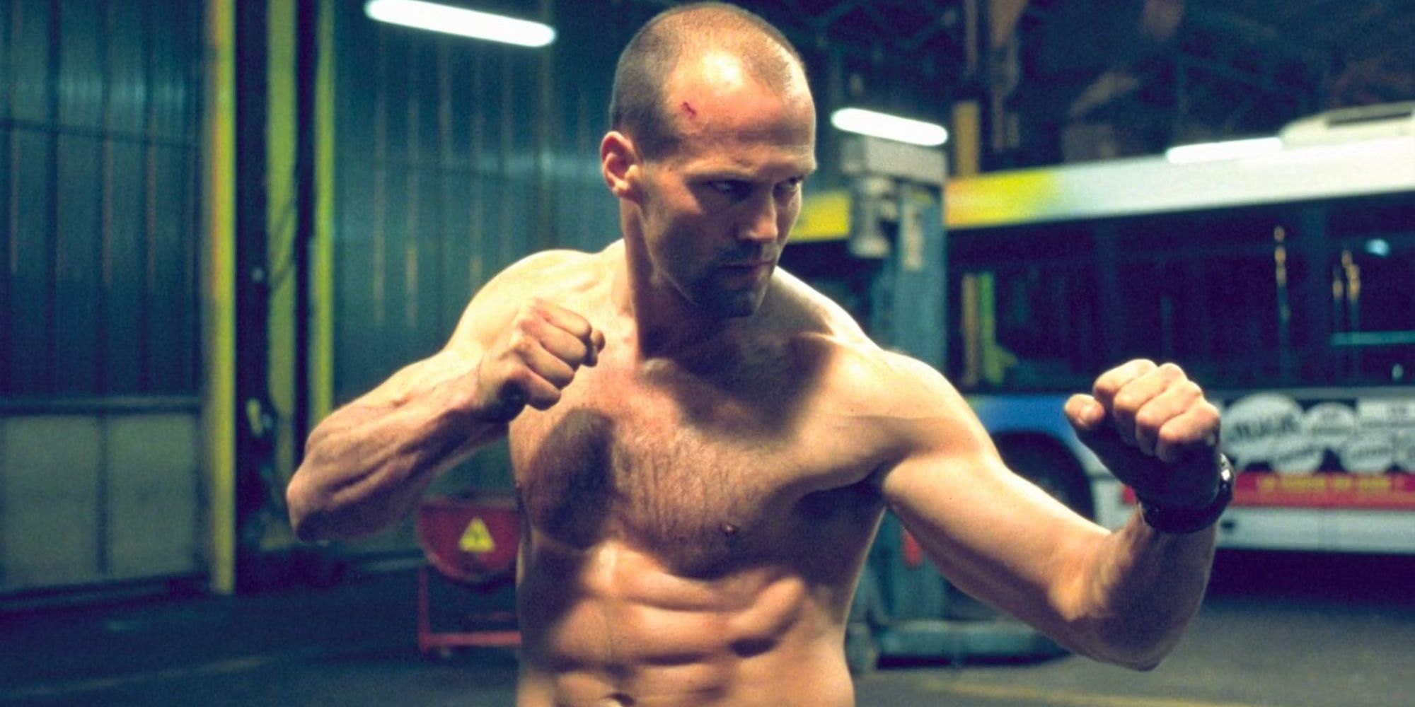 Jason Statham with his shirt off and his fists up ready to fight in The Transporter.