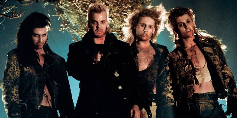 Paul, David, Dwayne and Marko inside a cave looking ahead in The Lost Boys.