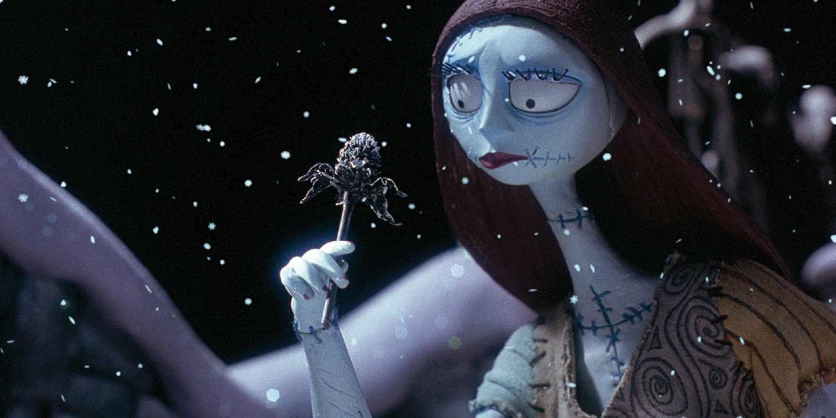Sally holding a spider lollipop in the snow in The Nightmare Before Christmas.