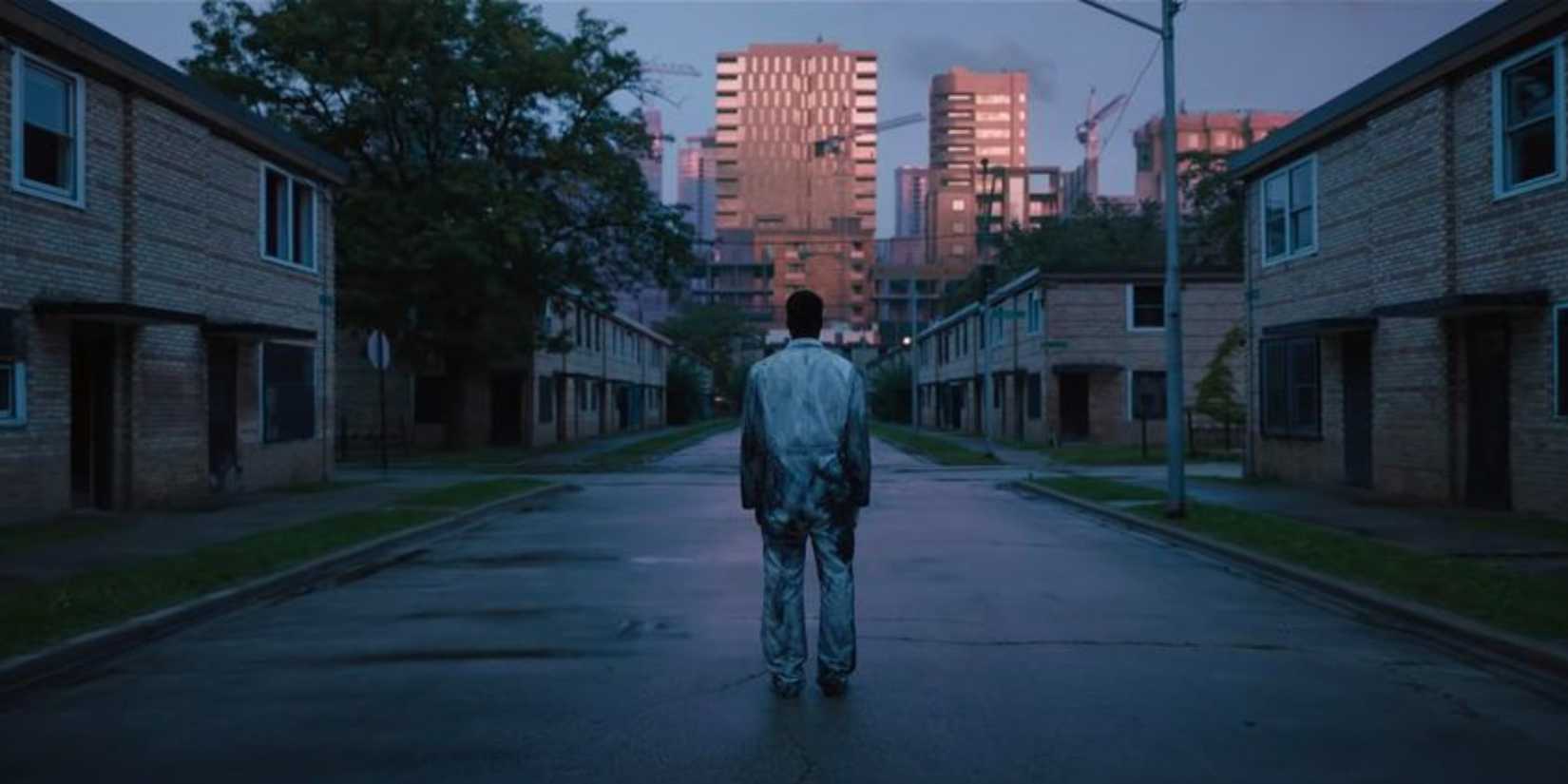 A man standing in the middle of a street with his back to the camera in Candyman