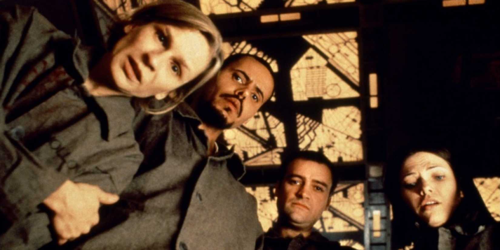 Nicole de Boer, Nicky Guadagni, David Hewlett, & Maurice Dean Wint looking down at an object in Cube 