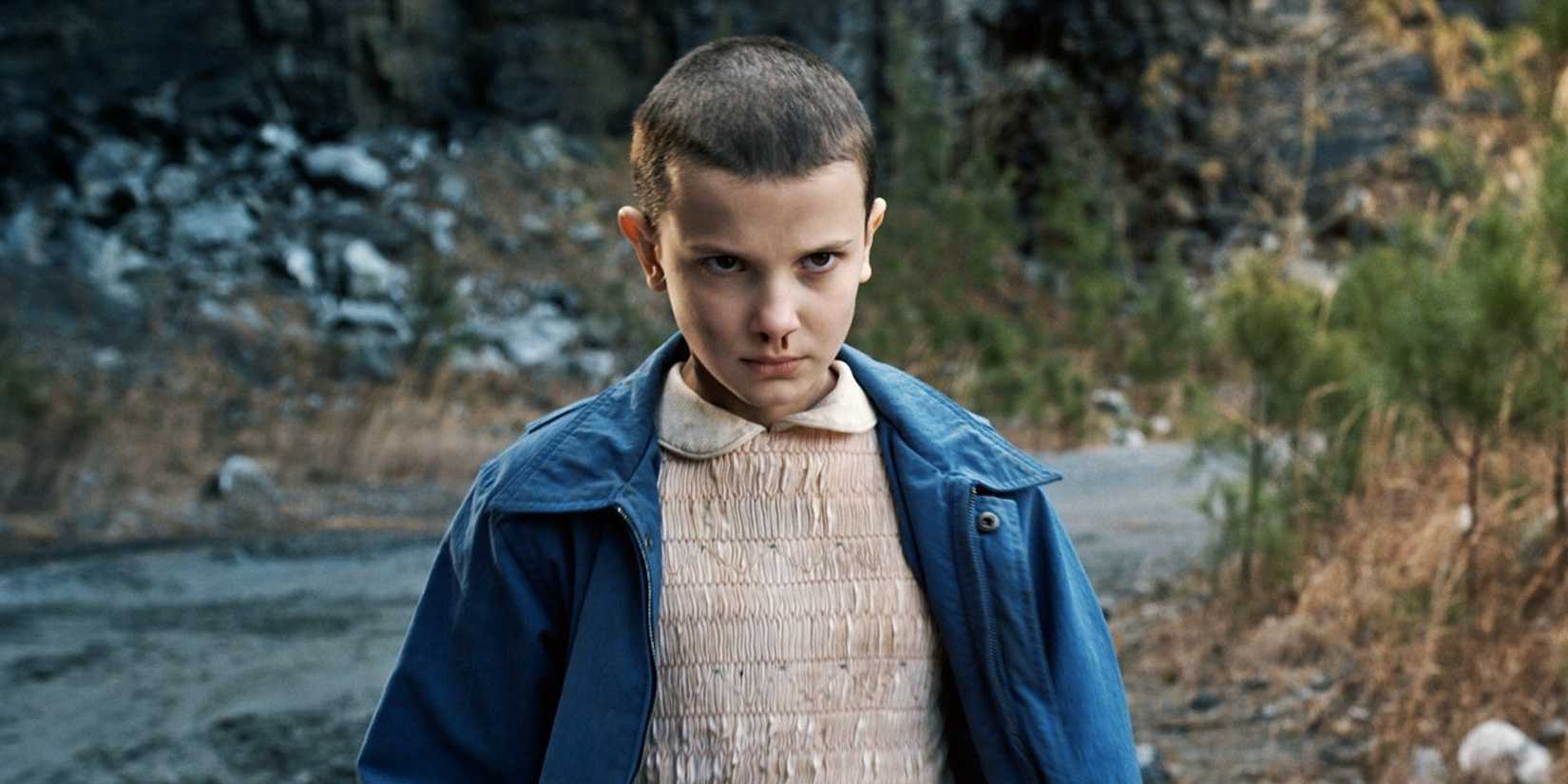 Millie Bobby Brown as Eleven staring intently with blood coming from her nose in Stranger Things Season 1.