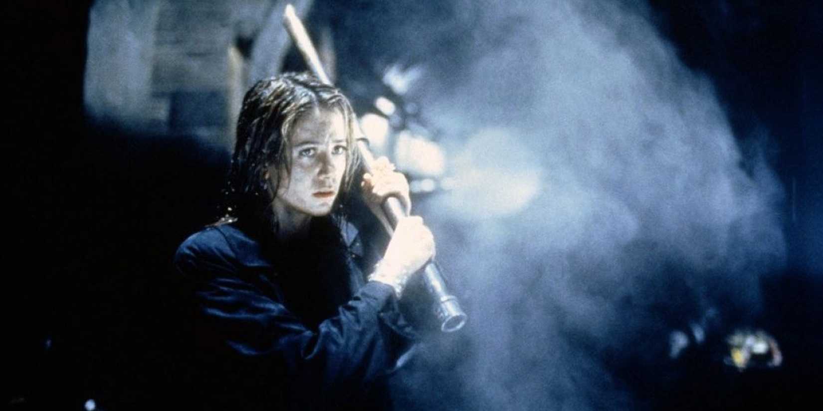 A woman holds a pipe as a weapon in a subway tunnel