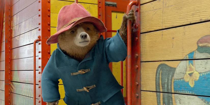 Paddington riding a train car in Paddington 2