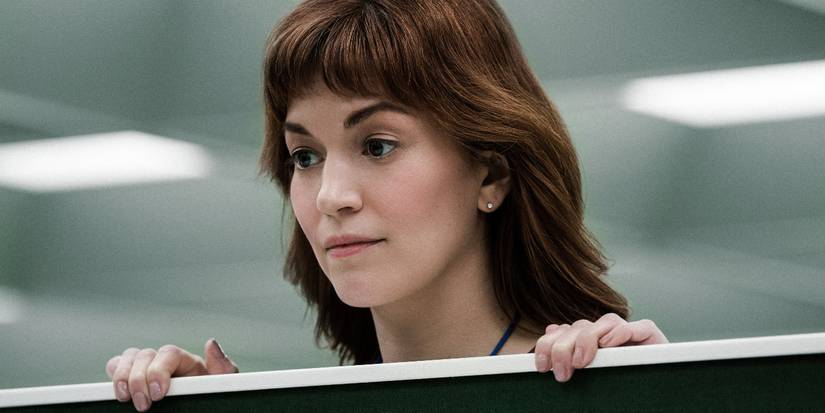 Britt Lower as Helly peeks over the top of a cubicle wall in Severance.
