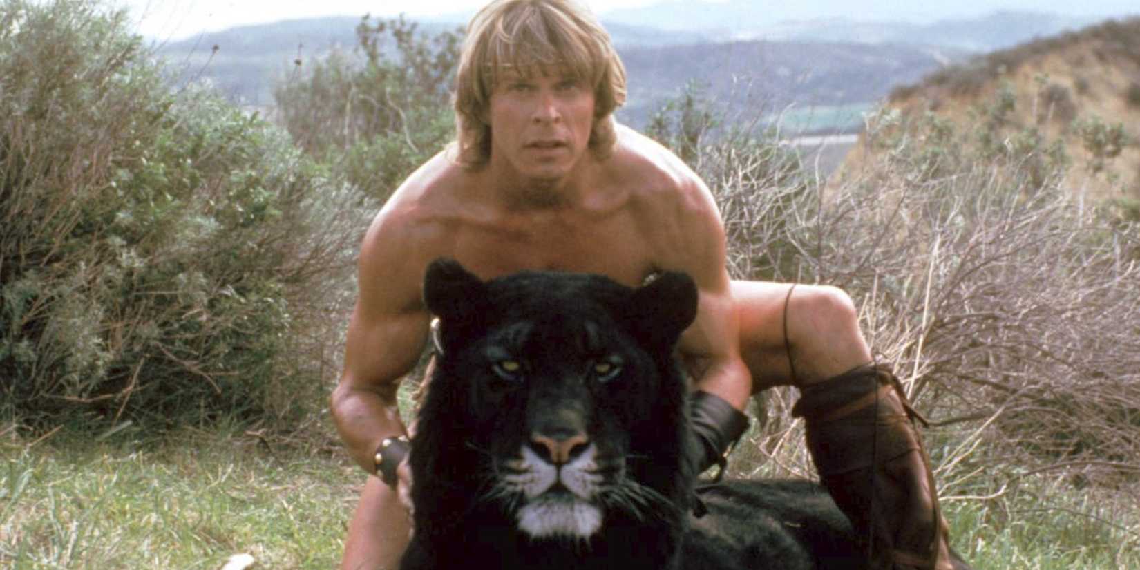 A man kneeling with a black tiger in Beastmaster
