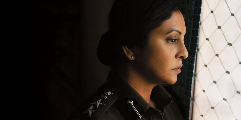 A woman officer looks out a gated window in the Delhi Crime miniseries.