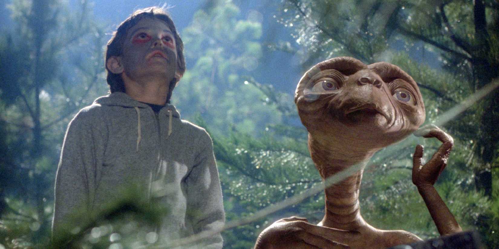 E.T. and Henry Thomas as Elliott looking up at the sky in the woods in 'E.T. the Extra-Terrestrial.'
