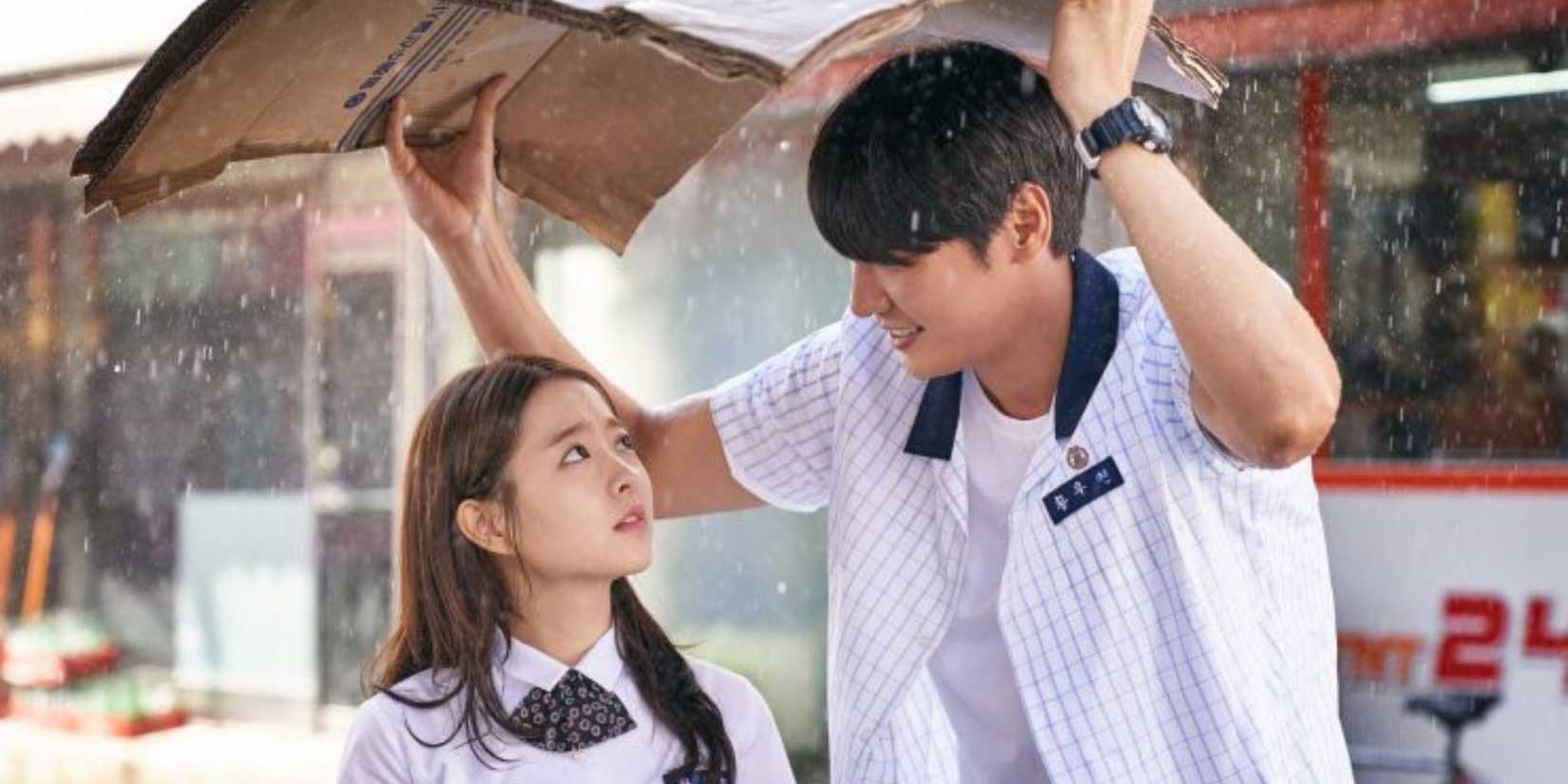 a boy covers a girl when it rains with his books